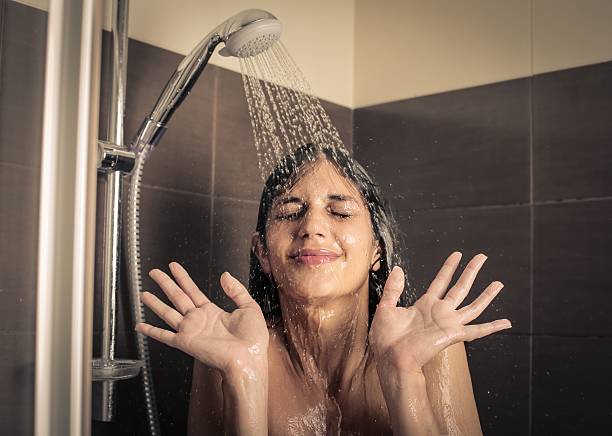 It is cold! Portrait of a girl who is standing under the shower and making a funny face because the water is cold bar of soap photos stock pictures, royalty-free photos & images