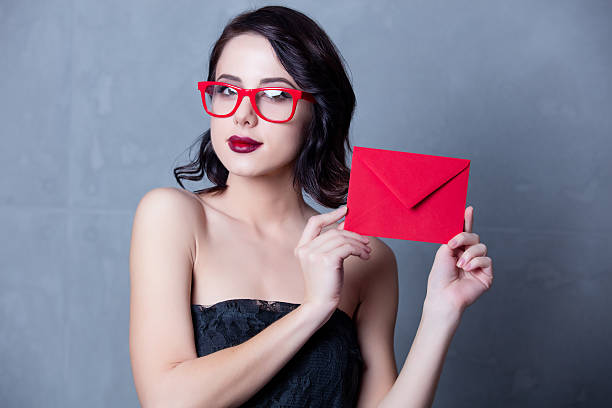 istock woman in black dress with envelope 625203410
