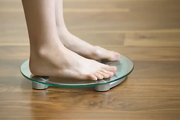 Photo of Female on standing on floor weight scales