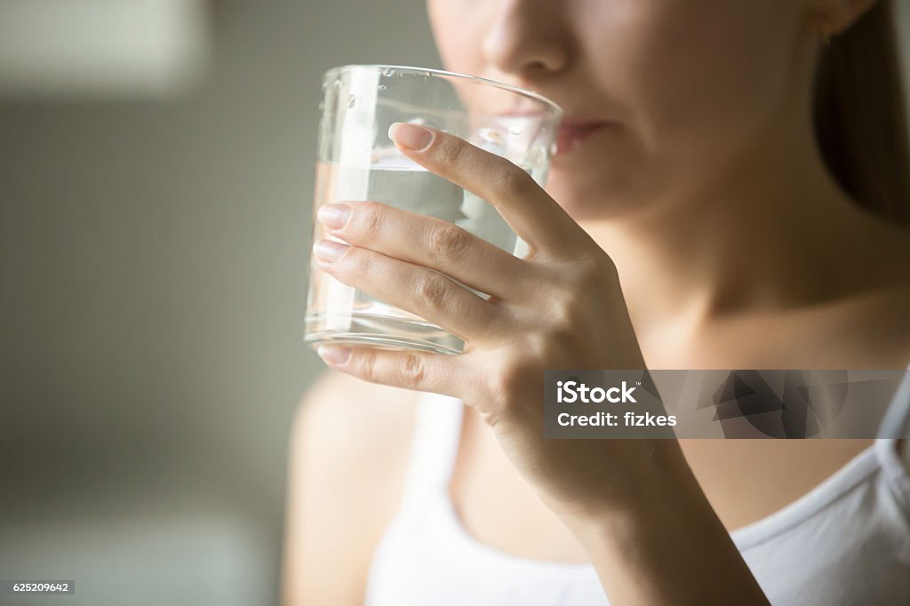 Female drinking from a glass of water Female drinking from a glass of water. Health care concept photo, lifestyle, close up Drinking Water Stock Photo