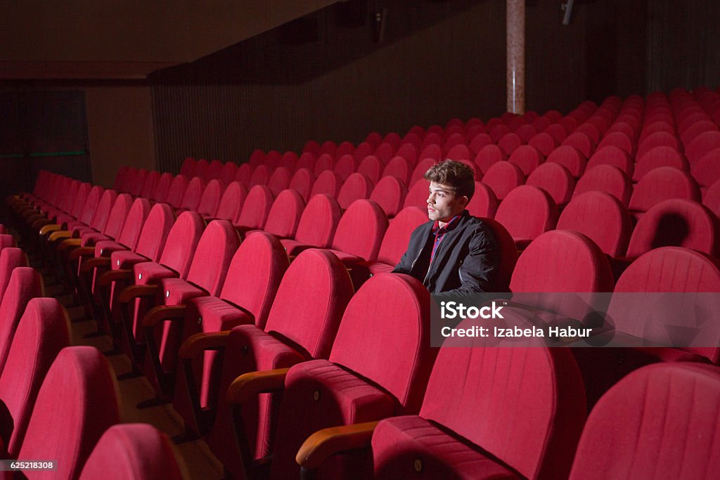 Young man in the cinema Young man in the movie theater, watching movie alone. Movie Theater Stock Photo
