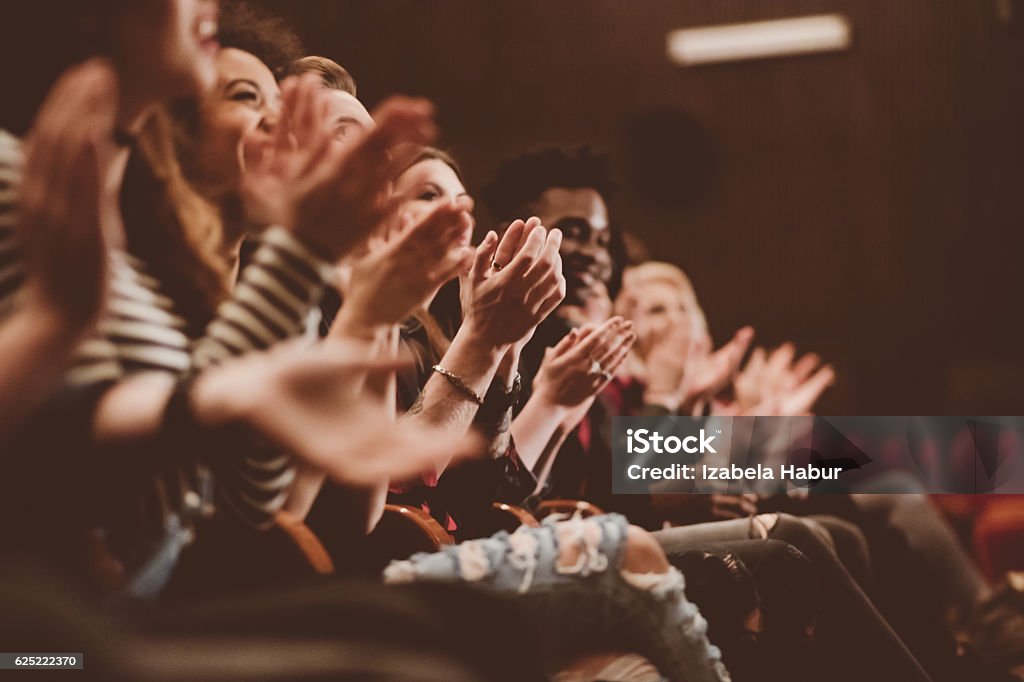 Audience applauding in the theater Group of people clapping hands in the theater, close up of hands. Dark tone. Theatrical Performance Stock Photo