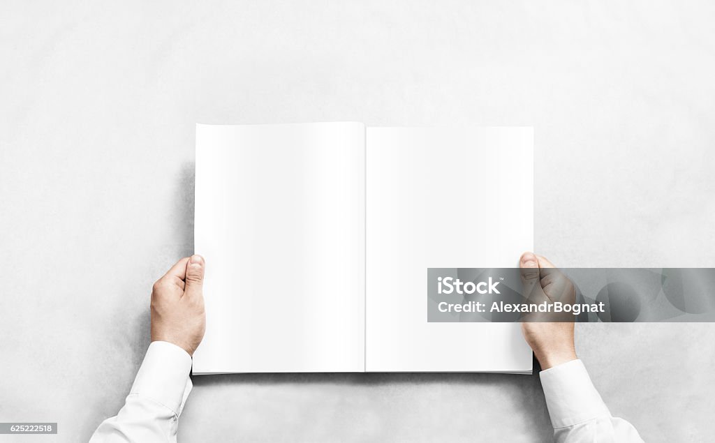 Hand opening white journal with blank pages mockup. Hand opening white journal with blank pages mockup. Arm in shirt holding clear magazine template mock up. Magazine - Publication Stock Photo