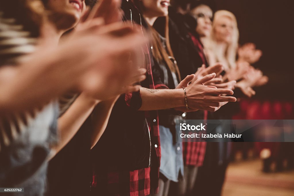 Audience applauding in the theater Group of people clapping hands in the theater, close up of hands. Dark tone. Applauding Stock Photo