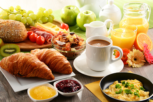 Desayuno servido con café, jugo, huevo y rollos photo