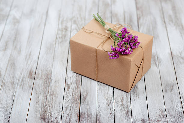 istock Gift box with dried flowers over wooden background. 625236734