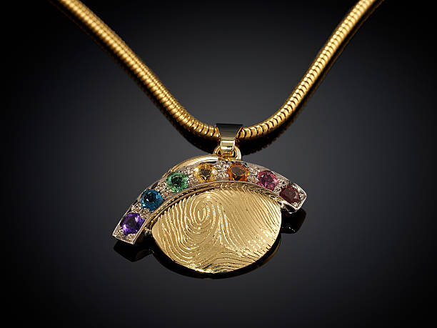 istock Golden necklace with gemstone isolated on black 625240950