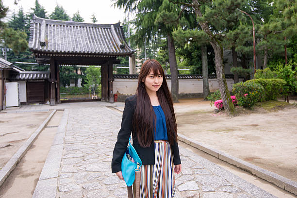 istock Young woman visiting temple 625243376