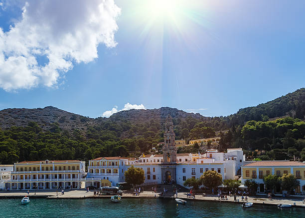 istock panormitis monastery in Symi island , sun clouds 625270166