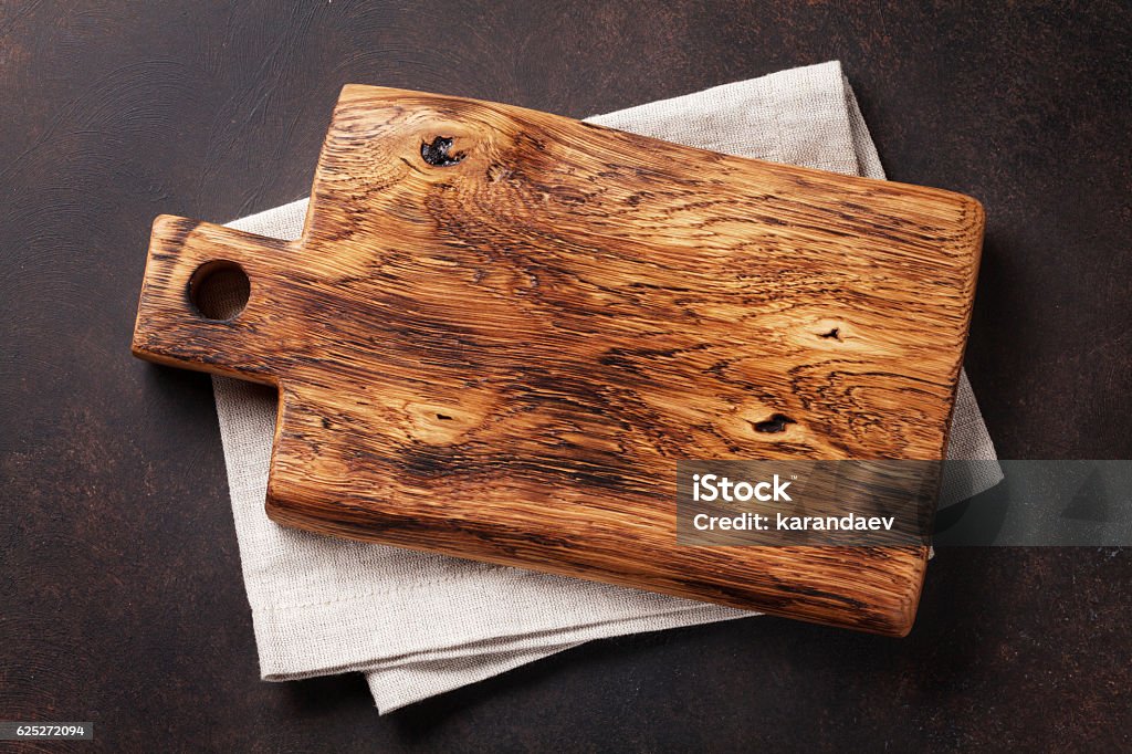 Cutting board over towel on stone kitchen table Cutting board over towel on stone kitchen table. Top view Cutting Board Stock Photo