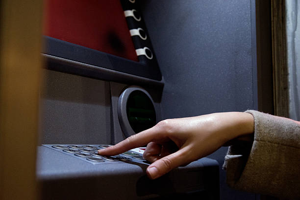 istock Woman hand Entering pin code on atm at night 625272578