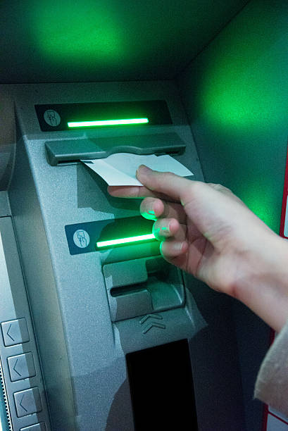 istock Woman's hand using  ATM on the street at night 625273260