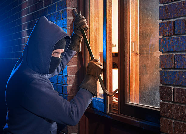 House break in by burglar Burglar Using Crowbar To Break Into a House at night with room left and right for type burglary crowbar stock pictures, royalty-free photos & images