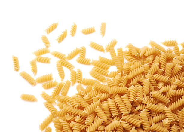 istock Pile of dry rotini pasta over isolated white background 625280528