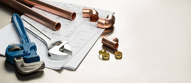 Plumbers Tools and Plumbing Materials Banner with Copy Space Various plumbers tools and plumbing materials including copper pipe, elbow joint, wrench and spanner. shot on a bright stainless steel background. Shot in banner format with space for text or copy. plumbing fixture stock pictures, royalty-free photos & images