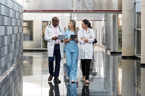 gruppo di medici che parlano in ospedale - healthcare and medicine smiling group of people lab coat foto e immagini stock