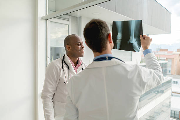 médecins examinant une x-ray - genou humain photos et images de collection