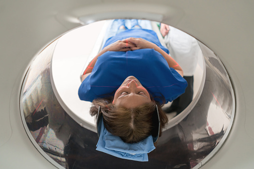 Adult female patient getting a CT scan at the hospital - medical exam concepts