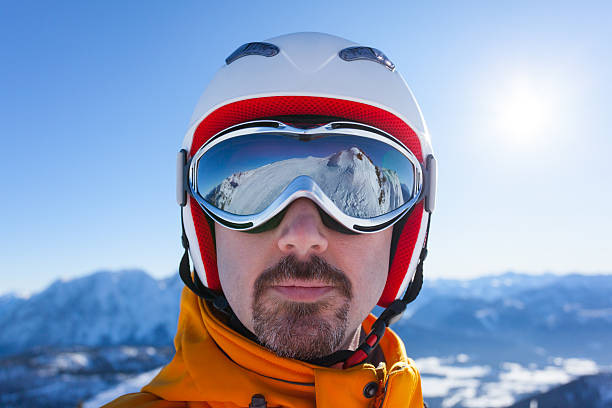 man with skiing goggles and reflections face of skier wearing a skiing helmet and goggles with reflections ski goggles stock pictures, royalty-free photos & images