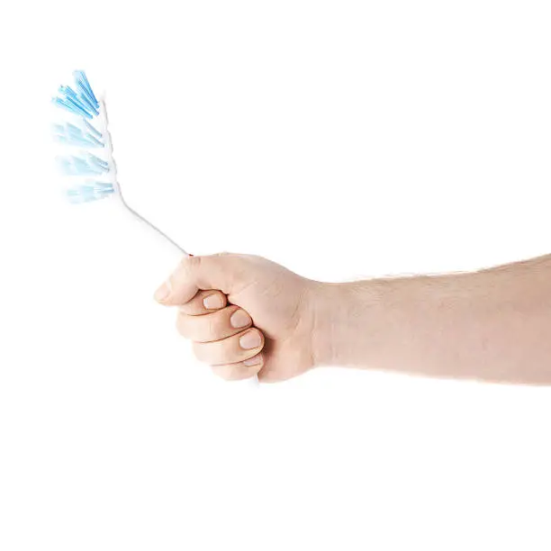 Caucasian male hand holding a dish brush, composition isolated over the white background