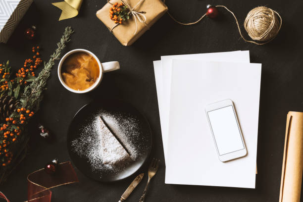 Overhead photo of cup of coffee notepad with pen glasses and plate with fruit cake isolated on the teal backdrop