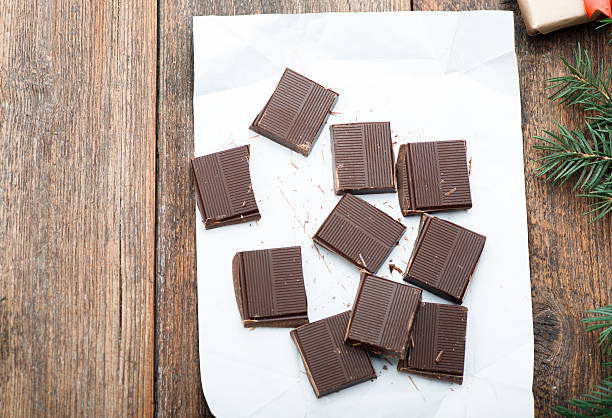 istock Dark chocolate bar broken in on the wooden table. Christmas 625300646