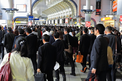 Tokyo, Japan-October 23, 2013: Hordes of salarymen along with career women and office ladies - terms for Japanese white-collar employees- daily assault the metro trains to go to work-Shinagawa station