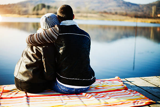 istock Loving couple sitting on a pier, hugging and looking away 625303410