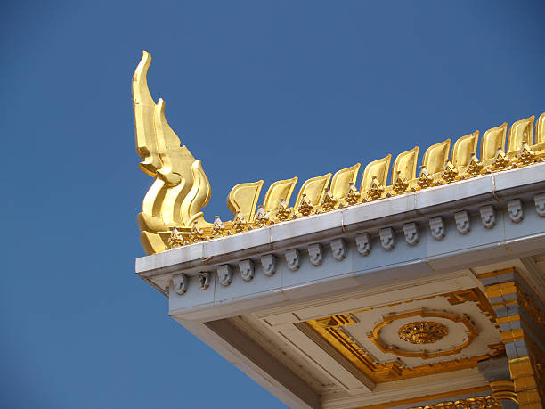 PHNOM PENH, CAMBODIA - Jan 2014: A monk walks past the golden-roofed Royal Palace in Phnom Penh, Cambodia.