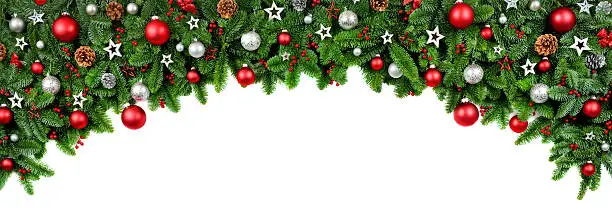 Wide arch shaped Christmas border isolated on white, composed of fresh fir branches and ornaments in red and silver