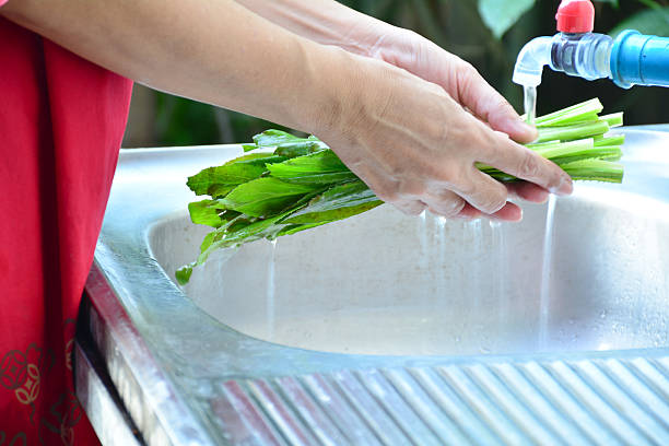 istock People washing vegetables by water in kitchen sink. 625306998