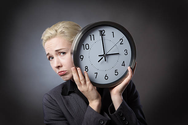 istock unhappy woman holds clock 625308392