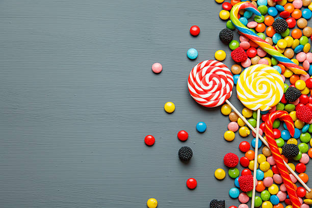 istock Colorful candies and lollipops over grey background. 625309540