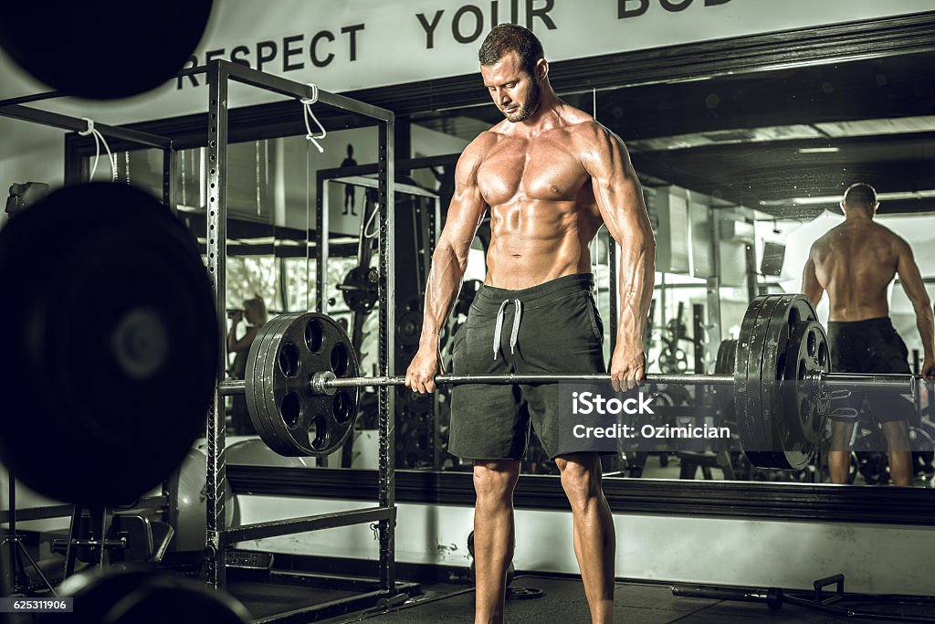 Deadlifts in modern gym Attractive tall muscular bodybuilder doing heavy deadlifts in moder fitness center. Toned image. Active Lifestyle Stock Photo