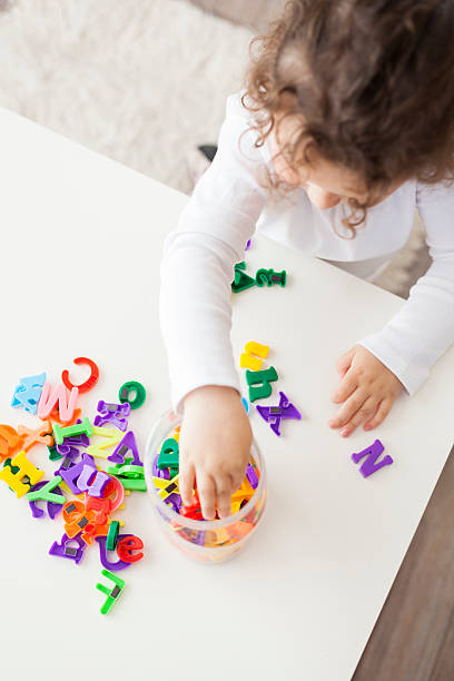 istock preschool girl playing with letters 625327350