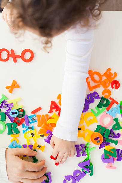 istock preschool girl playing with letters 625329326