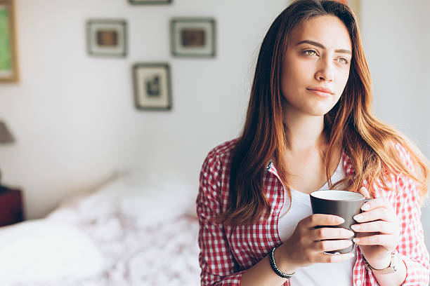 istock Young woman drinking coffee at home 625332156