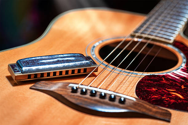 Acoustic guitar with blues harmonica country Acoustic guitar with country blues harmonica ready on stage nashville stock pictures, royalty-free photos & images