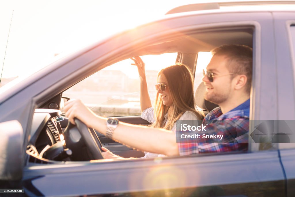 Couple driving in car Young couple driving in car Driving Stock Photo