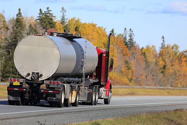 istock Tanker semi on an interstate highway, trees in background. 625356316