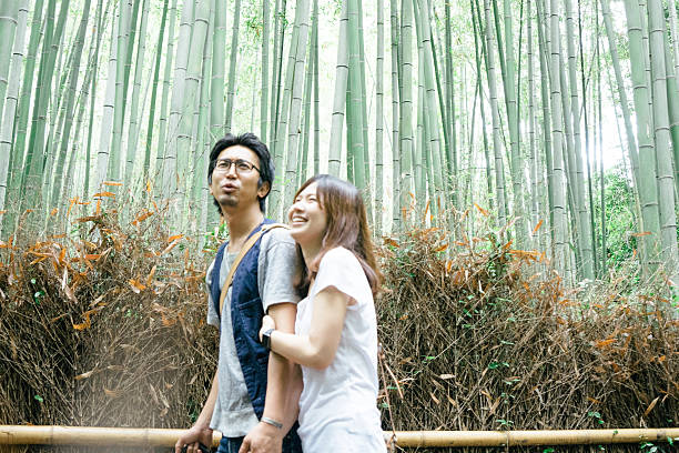 istock Cheerful Japanese couple walking through bamboo forest 625370378