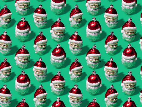 Super high resolution digital image of a repeating pattern of vintage Santa Claus Christmas ornaments on a green background. Image is 100% tileable, and was created as a pattern for gift wrap, backgrounds, cloth, and digital and web applications.
