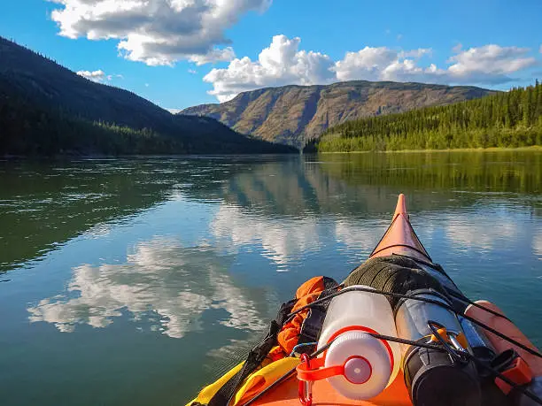 Personal point of view, adventure photo of the bow of a packed kayak while kayaking on the Yukon River, Yukon, Canada
