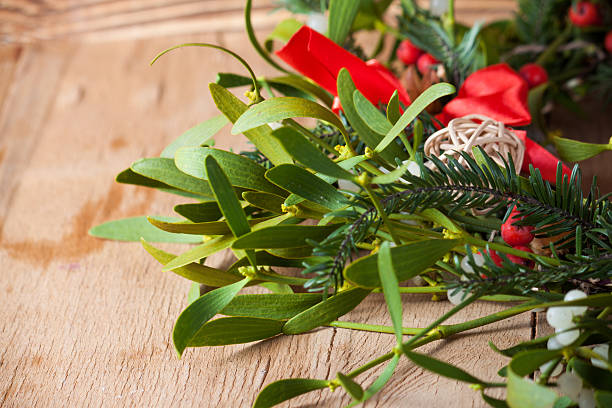 istock Green mistletoe on wood desk. 625381074