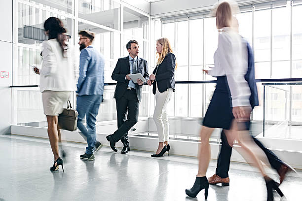 istock Businesspeople walking in busy office building 625381430
