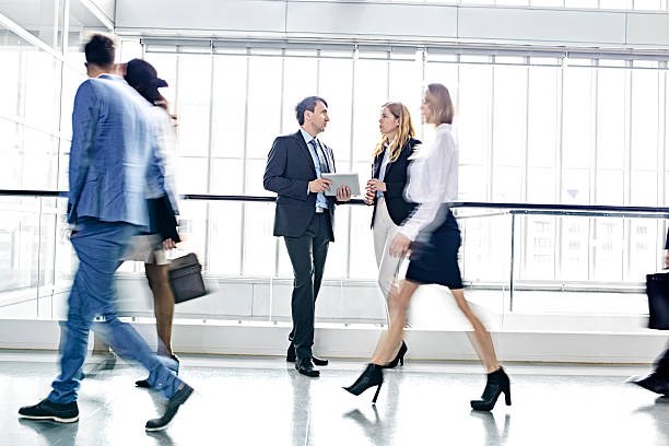 istock Businesspeople walking in busy office building 625381482