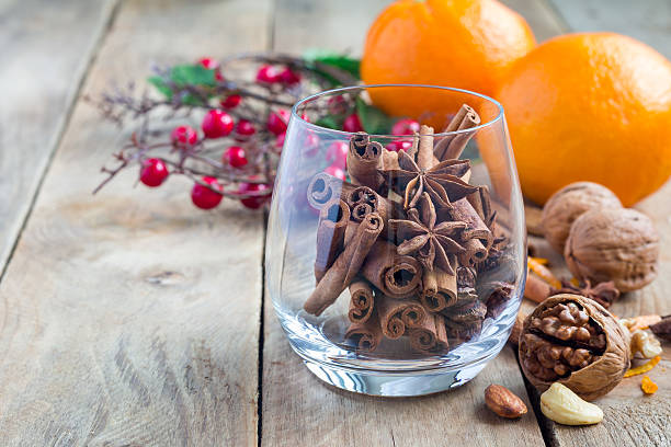 istock Cinnamon and anise in glass, oranges and nuts on background 625384712