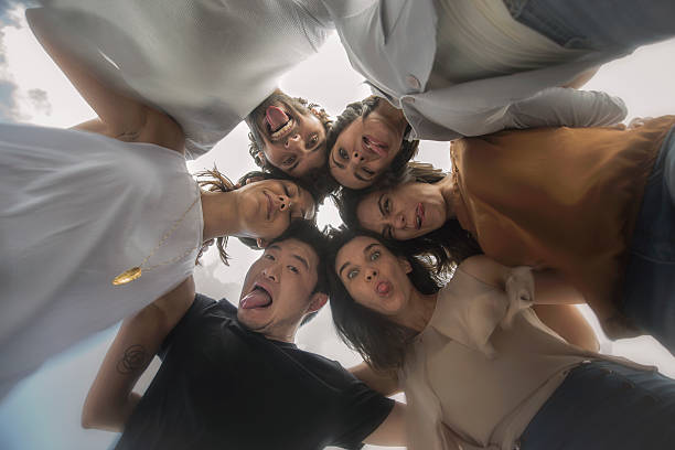 istock Young adults embracing in a circle making funny faces 625385084