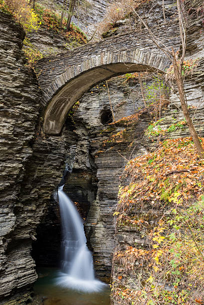 Autumn Bridge Waterfall Waterfall comes flying down the gorge under a bridge lake seneca stock pictures, royalty-free photos & images