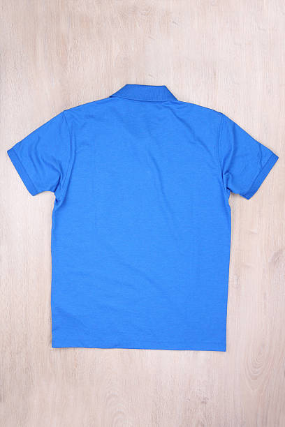 istock Back view blue polo shirt on wooden background 625387510